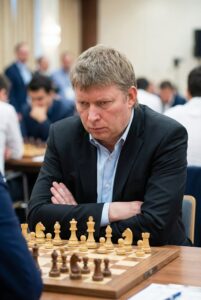 Олексій Широв за шахівницею під час партії, гросмейстер у зосередженій позі, класична турнірна атмосфера