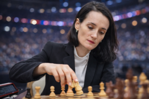 Kateryna Lagno führt während einer Partie bei einem internationalen Schachturnier konzentriert einen Zug mit einer weißen Figur aus.