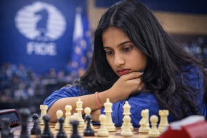 Divya Deshmukh analysiert während einer Partie bei einem internationalen Turnier aufmerksam die Stellung auf dem Schachbrett.