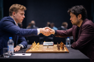 Dois enxadristas apertam as mãos por cima do tabuleiro após uma partida tensa em um salão de torneio, encerrando o confronto em uma atmosfera contida e profissional.