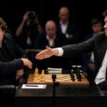 Two professional chess players are seated at a tournament board. One player extends a hand in greeting while the other visibly refuses the handshake. The atmosphere is tense, with chess pieces and clocks on the table and spectators and photographers visible in the background.